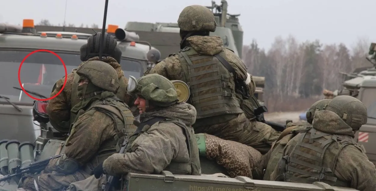 Белорусский флажок за стеклом машины с российскими военными
