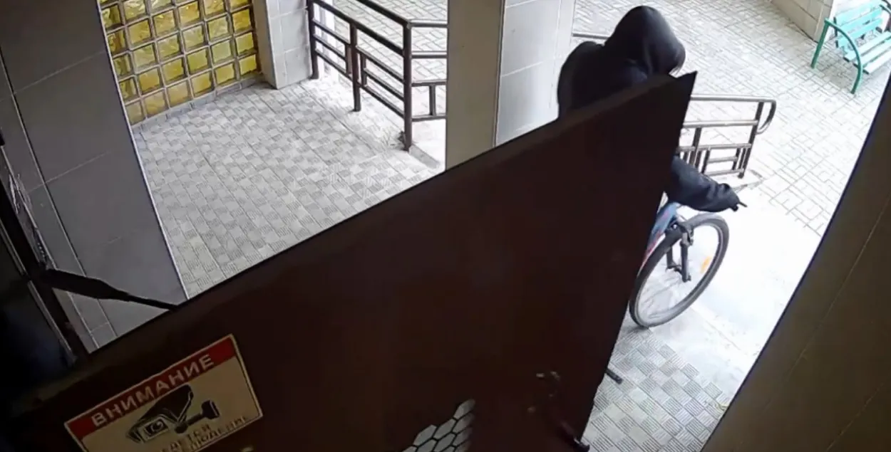 Скрадзены ровар выносіцца з пад'езда дома / Скрыншот з відэа мінскай міліцыі
