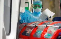 Медики перевозят в специальном боксе больного на&nbsp;COVID-19, Беларусь / Reuters