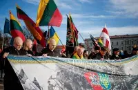 Бело-красно-белый флаг на шествии в Вильнюсе
