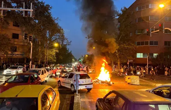 Горящий полицейский мотоцикл во время протестов в Тегеране / Reuters

