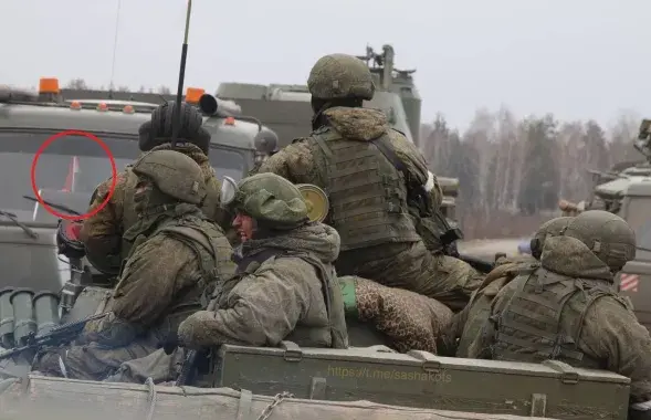 Беларускі сцяжок за шклом машыны з расійскімі вайскоўцамі
