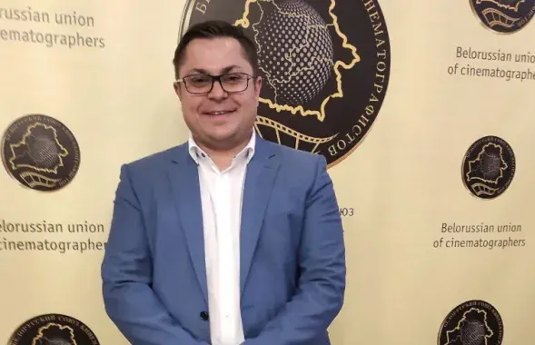 Евгений Арендаревич на фоне логотипа Белорусского союза кинематографистов
