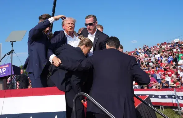 Раненого Трампа уводят со сцены
