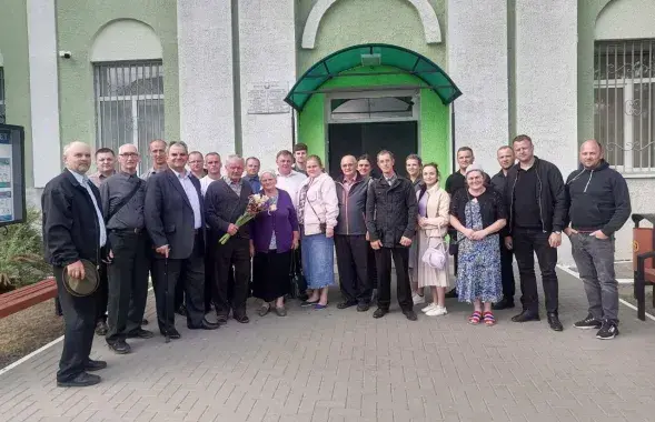Чальцы баптысцкай царквы прыйшлі падтрымаць пастара (ён з кветкамі) да будынка суда ў 2023 годзе
